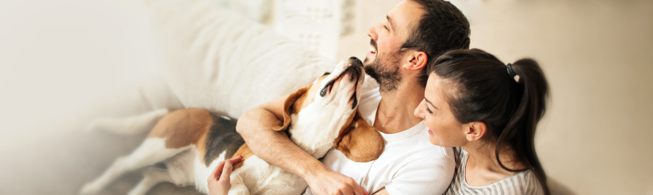 A couple sitting together with their dog in their apartment