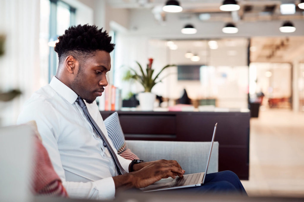 Man working remotely on a laptop in a co-working space at his apartment