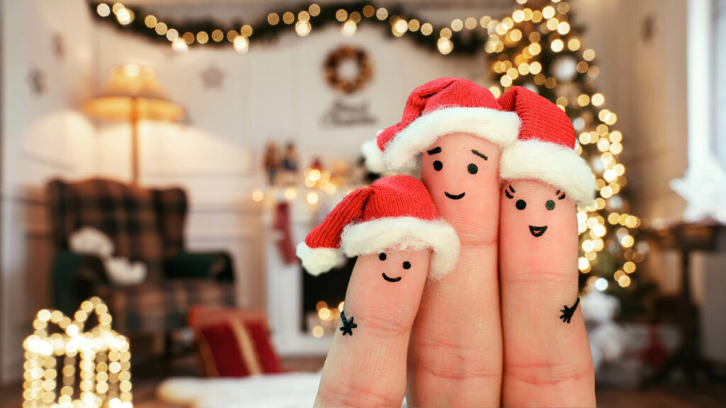 Family Christmas gathering represented by three fingers in Santa hats