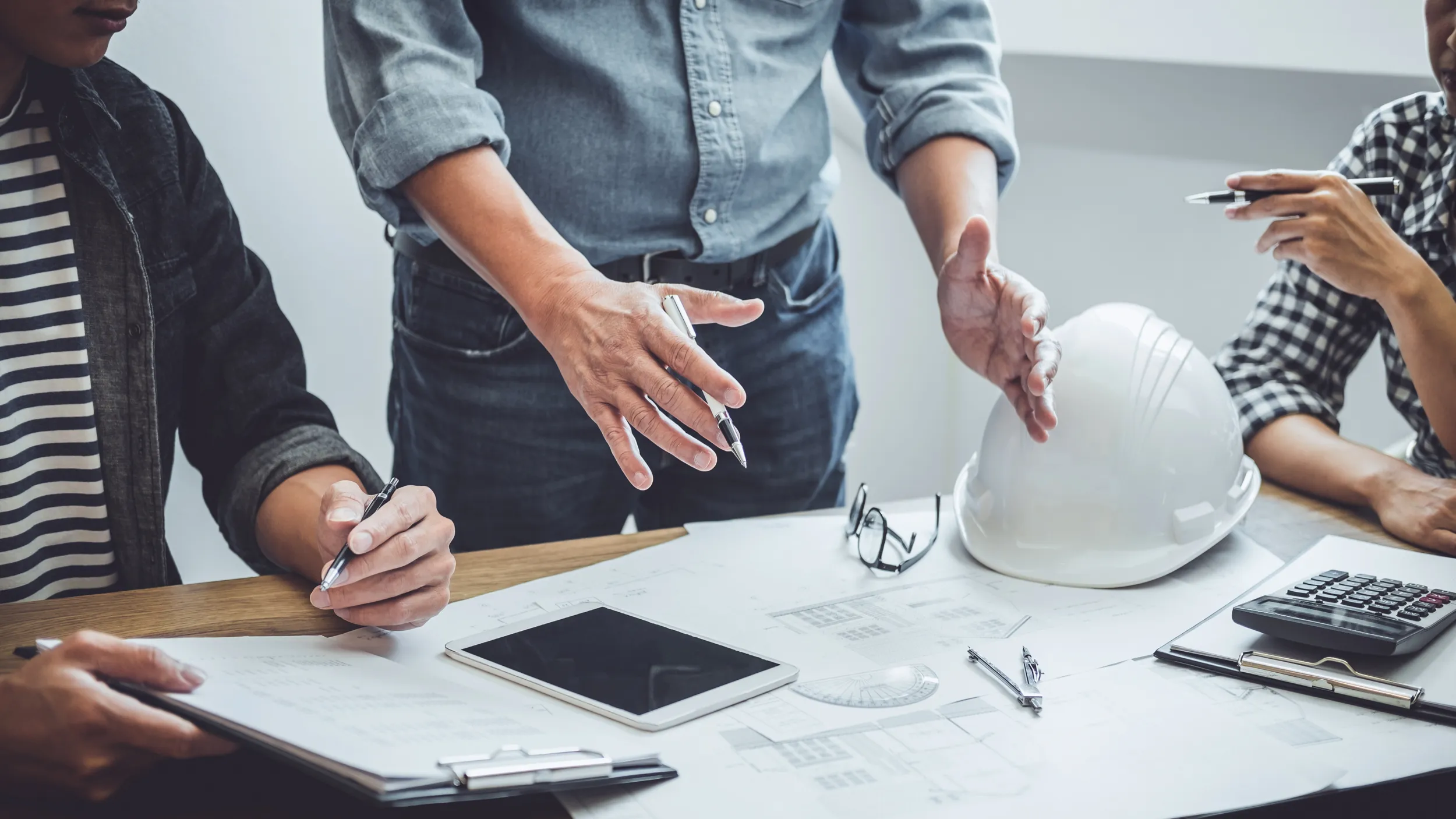 People gathered around a table to discuss a building project.