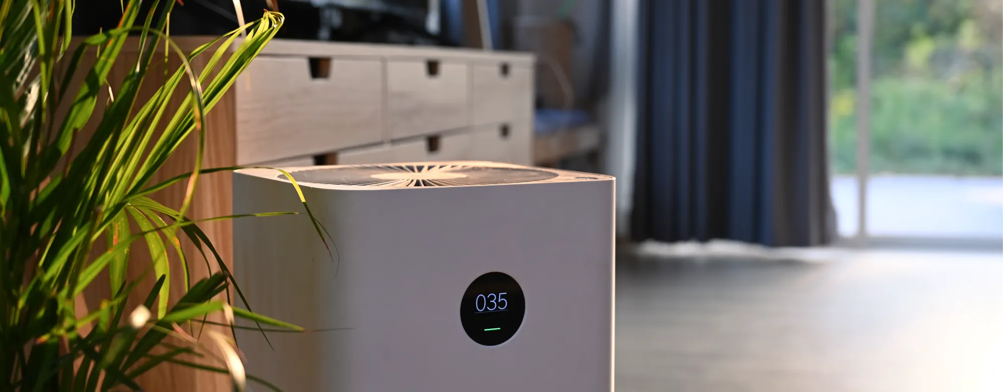 Air purifier set in front of a bedroom dresser to improve indoor air quality (IAQ).