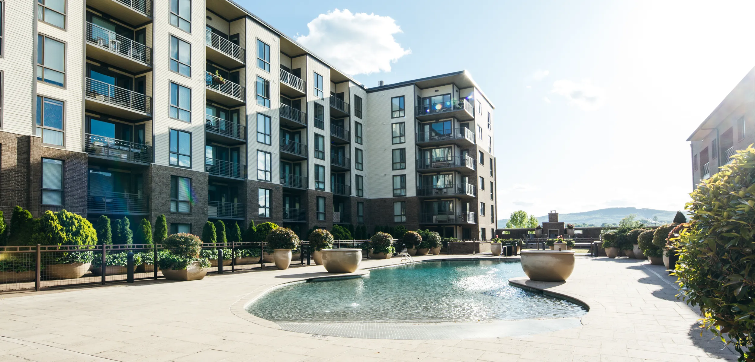 Multi-unit apartment building with a pool courtyard.